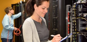 Woman IT engineer in server room checking network