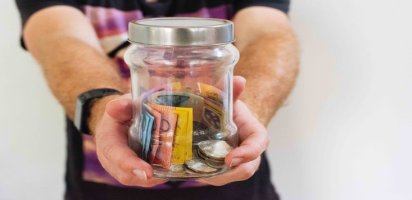 hands-holding-out-jar-of-money