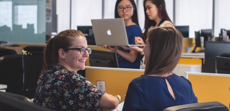 desk bombed – workers stop by for an impromtu chat at a colleague's desk