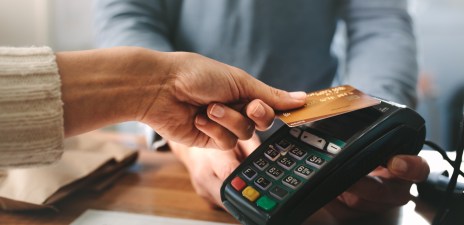 Pharmacist accepting credit card by contactless payment. Woman purchasing products in the pharmacy. Pharmacist hands charging with credit card reader. ato